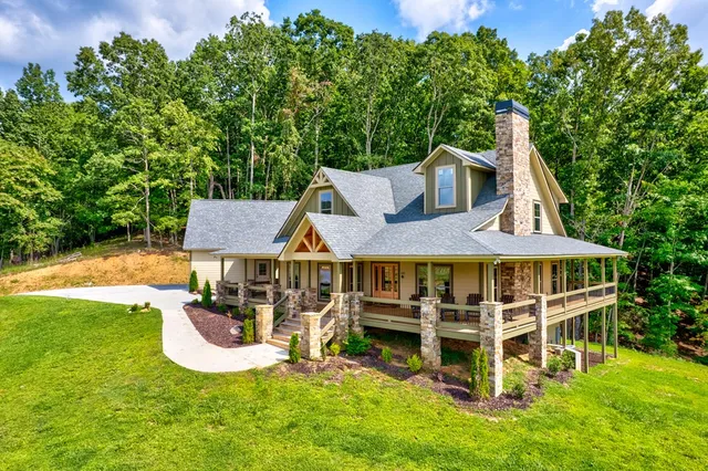 an aerial view of a house with swimming pool garden view and trees