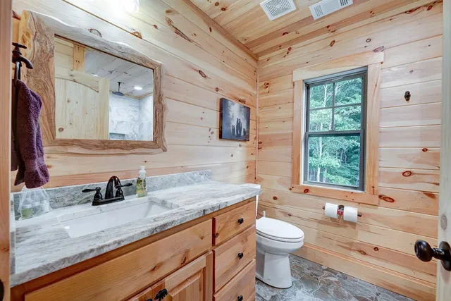a bathroom with a granite countertop sink toilet a large mirror and a bathtub