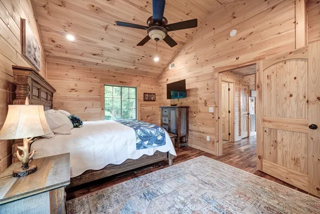 a bedroom with a bed window and a flat screen tv