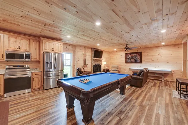 a living room with stainless steel appliances kitchen island furniture and a wooden floor
