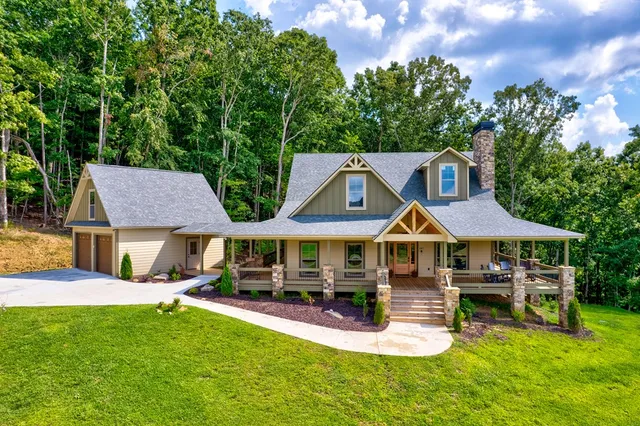 a view of a white house with a big yard and large trees
