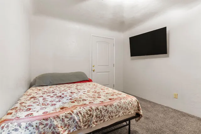 a bedroom with a bed and a flat screen tv