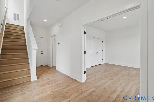a view of an empty room with wooden floor