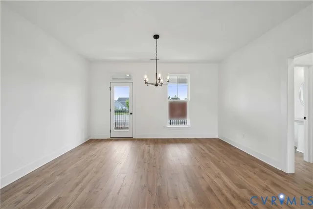 a view of a room with wooden floor chandelier and window