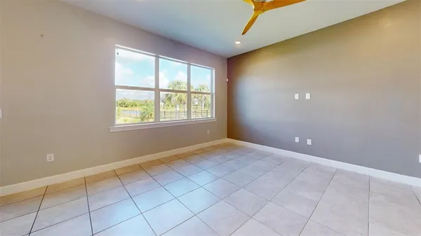 a view of an empty room and chandelier fan