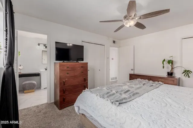 a bedroom with a bed and a flat tv screen on dresser