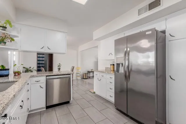 a kitchen with white cabinets and stainless steel appliances