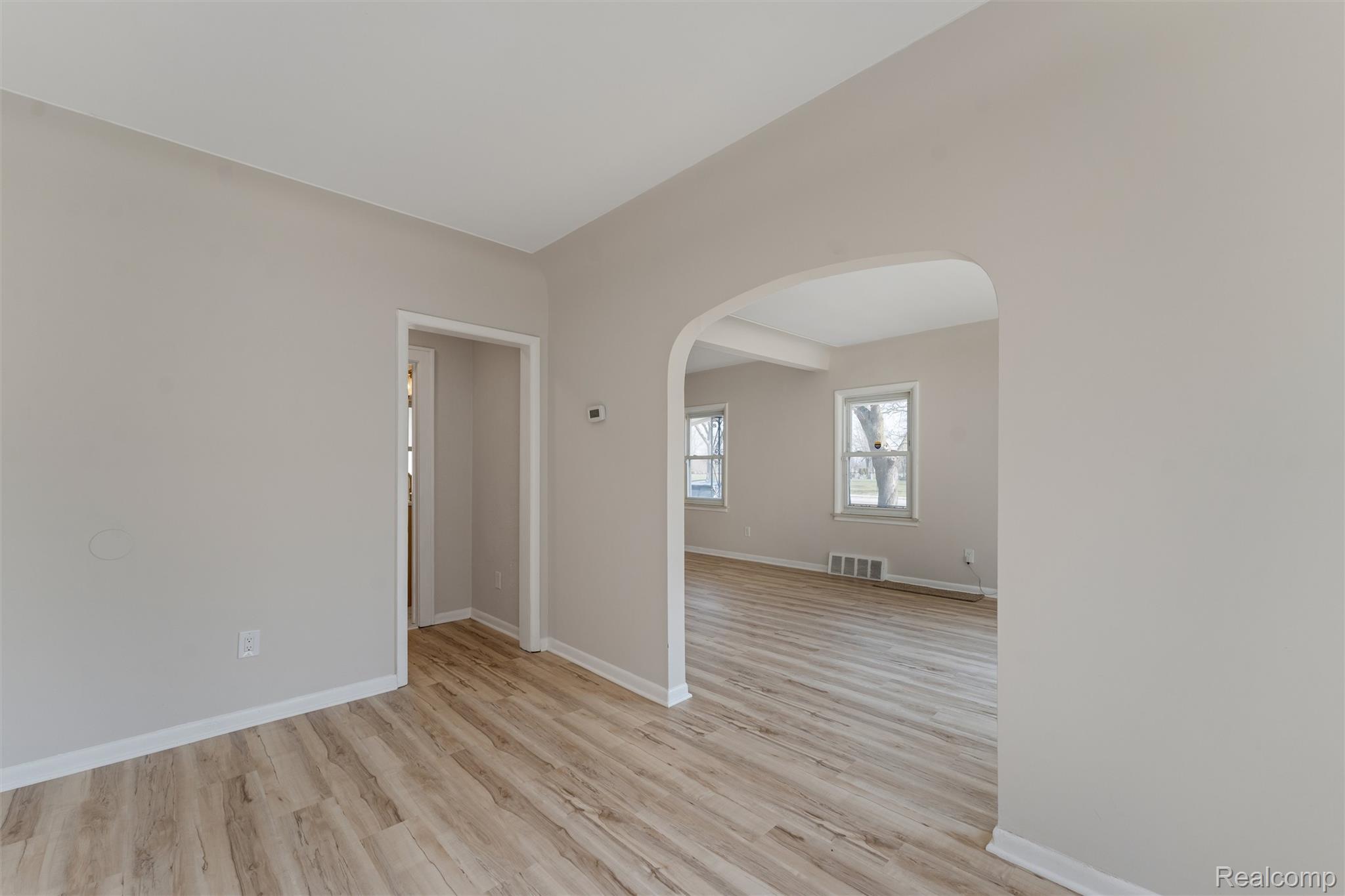 917 Perry Street Pontiac, MI 48340 - Photo 13 of 37 Empty room with arched walkways and light wood finished floors