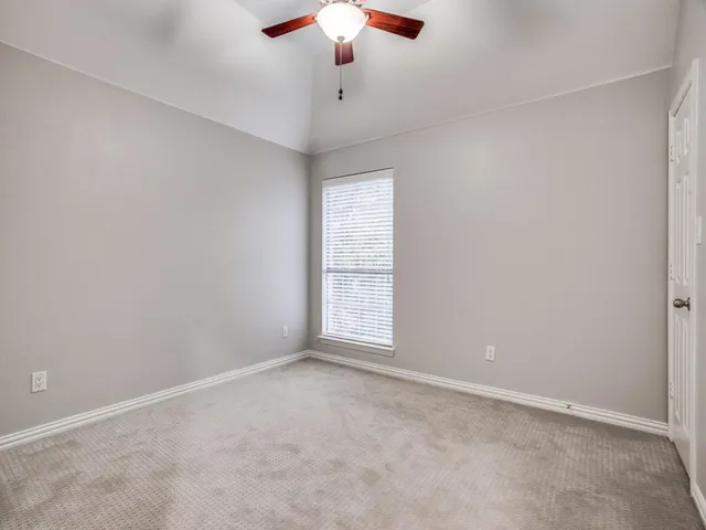 an empty room with a chandelier fan