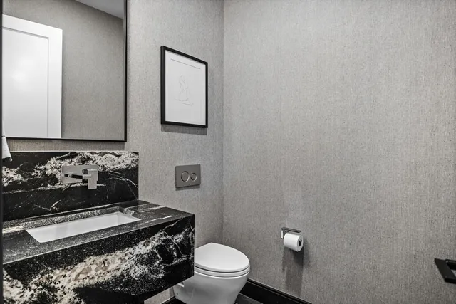 a bathroom with a toilet a sink and mirror