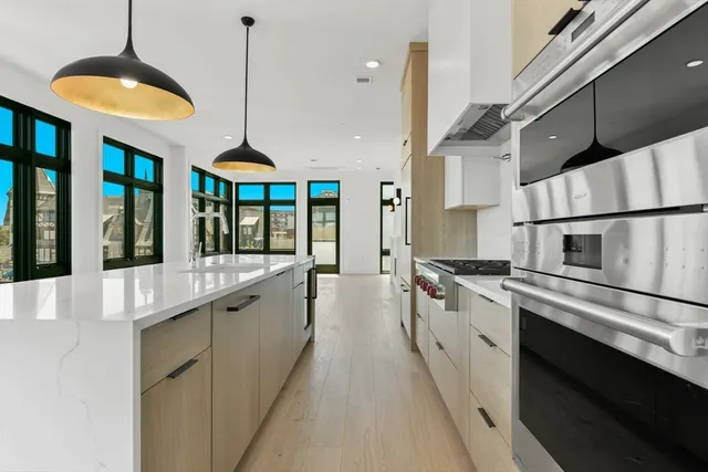 a kitchen with stainless steel appliances granite countertop a sink a stove and a refrigerator