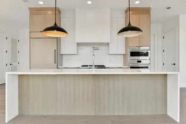 a kitchen with stainless steel appliances granite countertop a sink a stove and a refrigerator