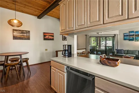 a kitchen with stainless steel appliances granite countertop a sink dishwasher a stove and cabinets with wooden floor