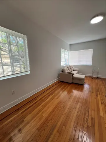 a living room with hard wood floors and a window