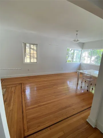 a view of a room with window and hardwood floor