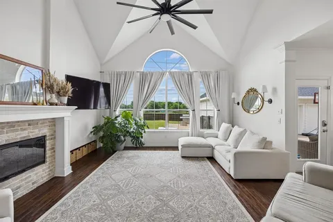 a living room with furniture a fireplace and a large window