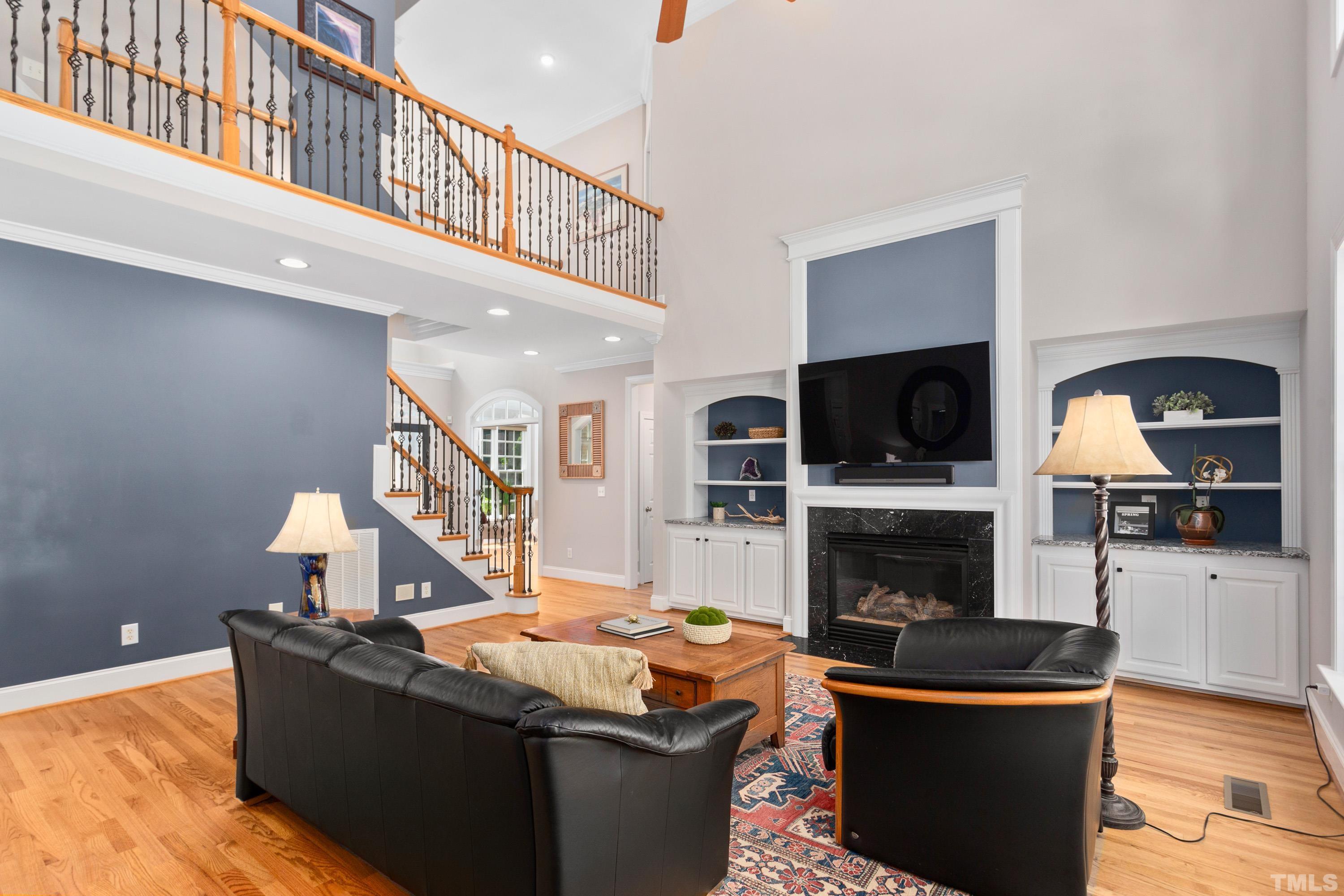 3728 Grandbridge Drive Apex, NC 27539 - Photo 11 of 76 a living room with furniture a fireplace and a flat screen tv