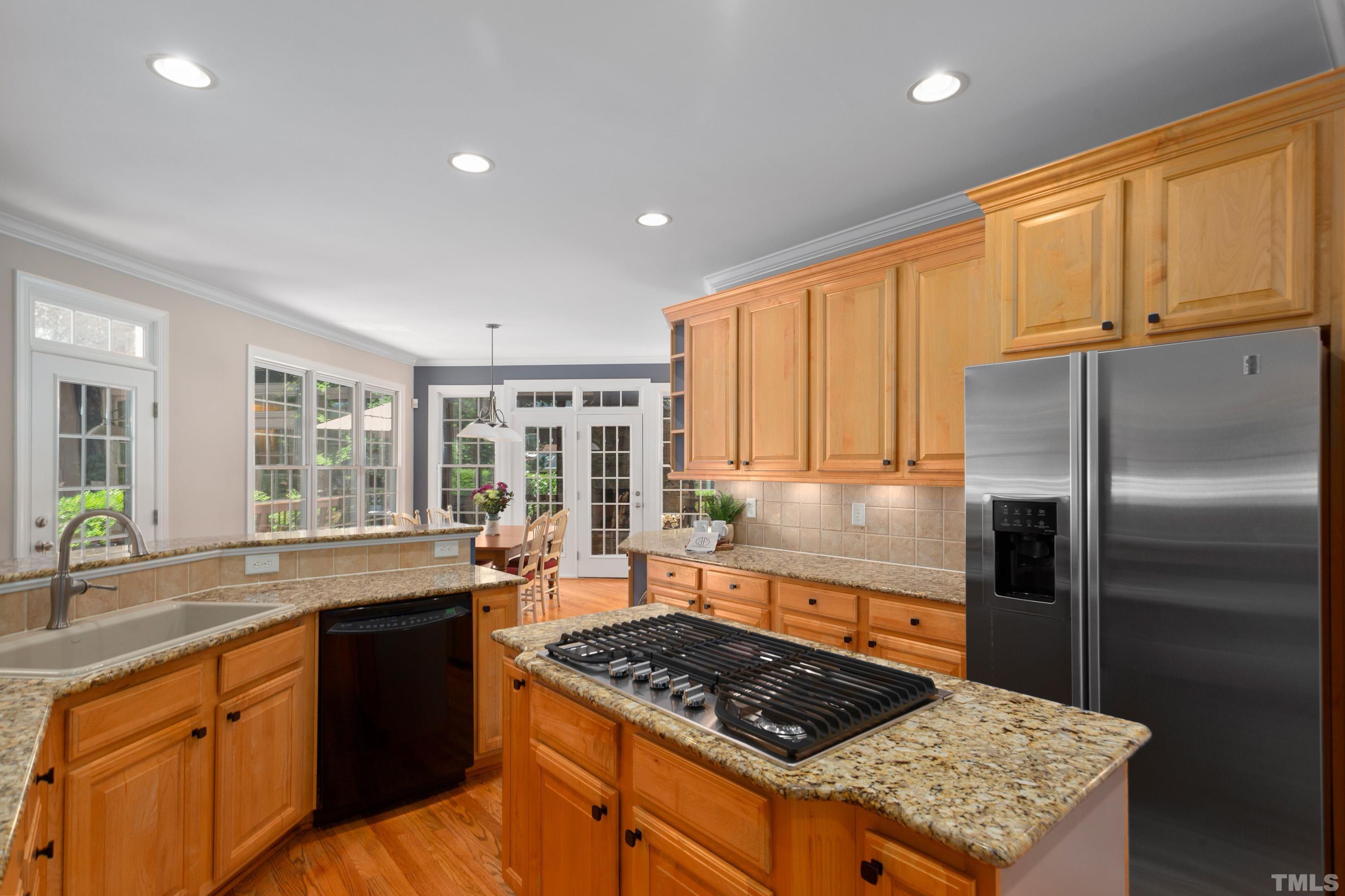 3728 Grandbridge Drive Apex, NC 27539 - Photo 17 of 76 a kitchen with stainless steel appliances granite countertop a sink stove and refrigerator