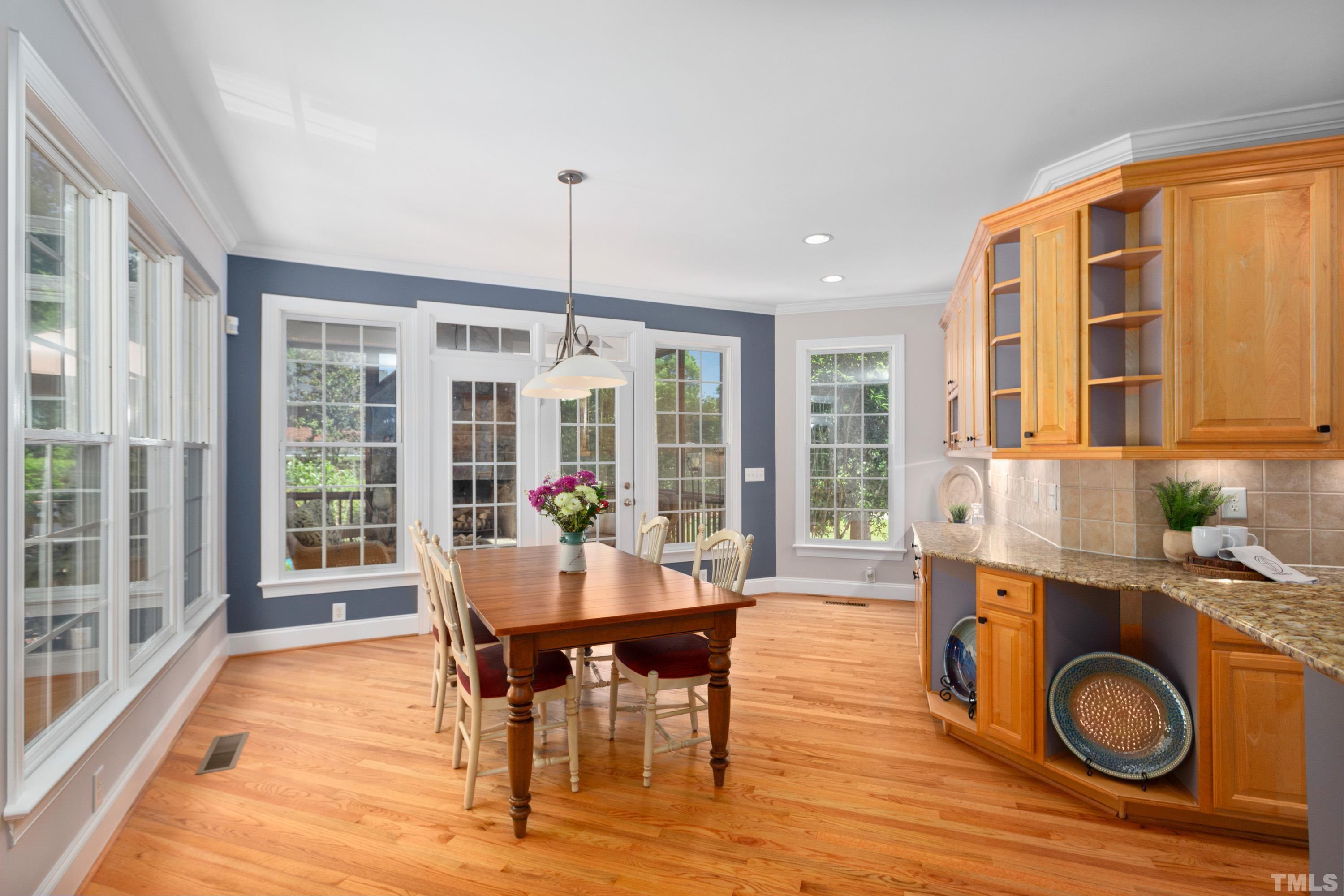 3728 Grandbridge Drive Apex, NC 27539 - Photo 21 of 76 a dining room with furniture a fireplace and wooden floor