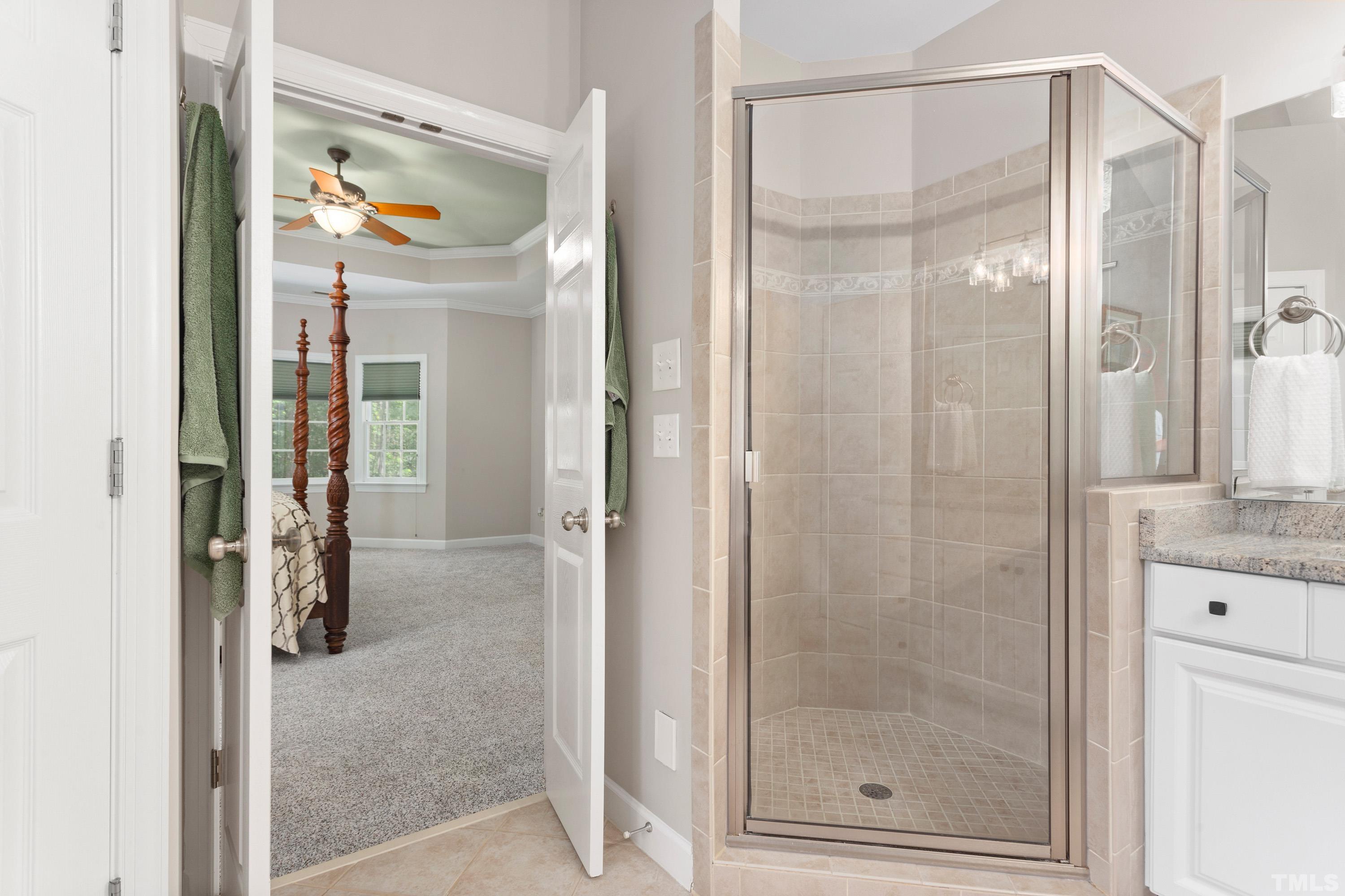 3728 Grandbridge Drive Apex, NC 27539 - Photo 38 of 76 a bathroom with a glass shower door and mirror