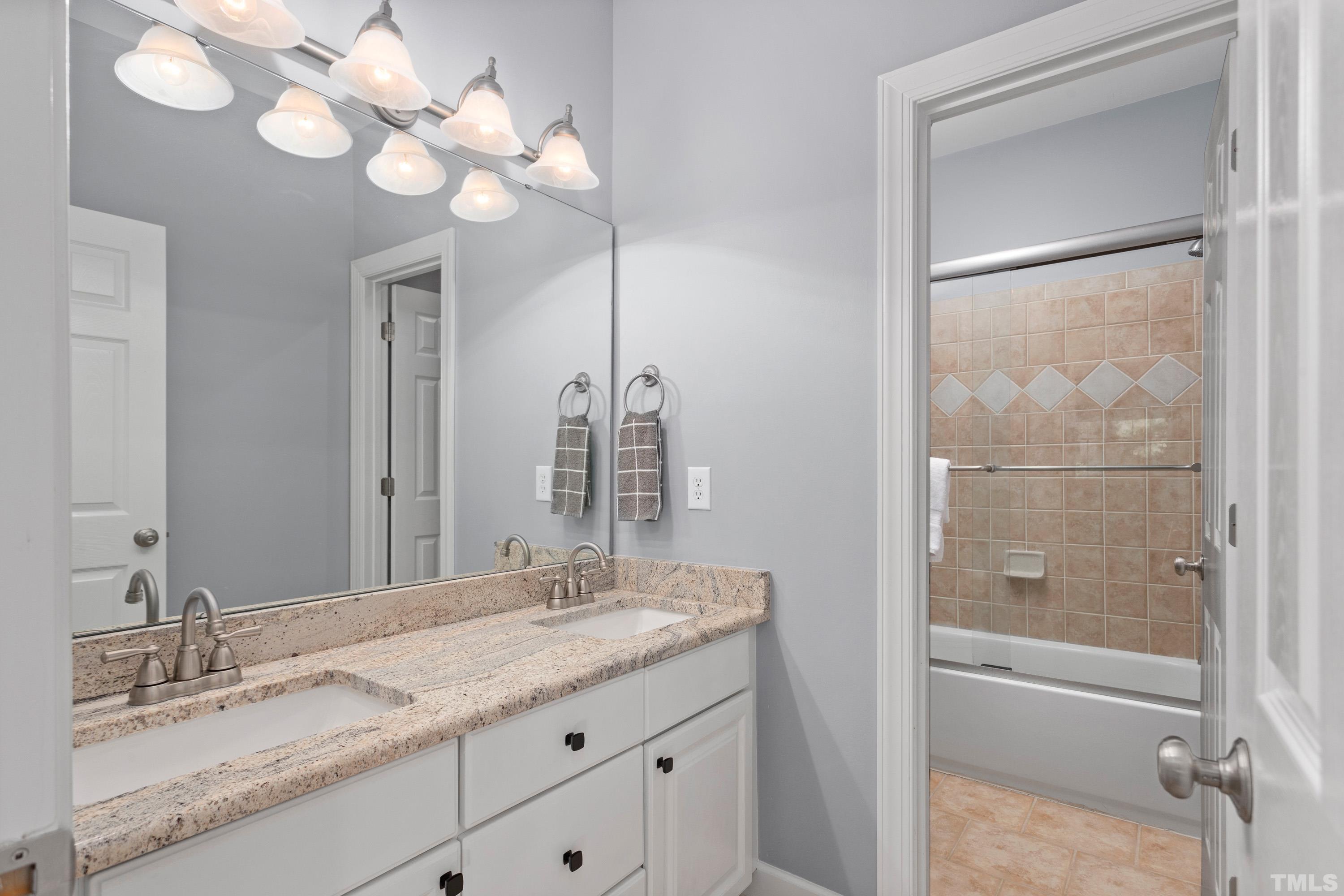 3728 Grandbridge Drive Apex, NC 27539 - Photo 44 of 76 a bathroom with a granite countertop sink mirror and a shower