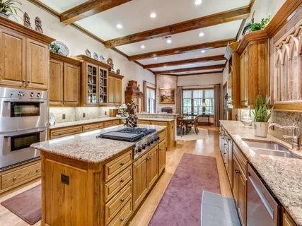 a dining hall with stainless steel appliances granite countertop a sink and a refrigerator
