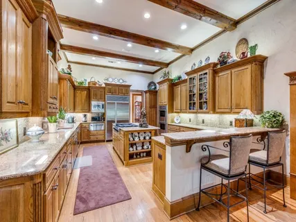 a kitchen with stainless steel appliances granite countertop a stove a sink and a refrigerator