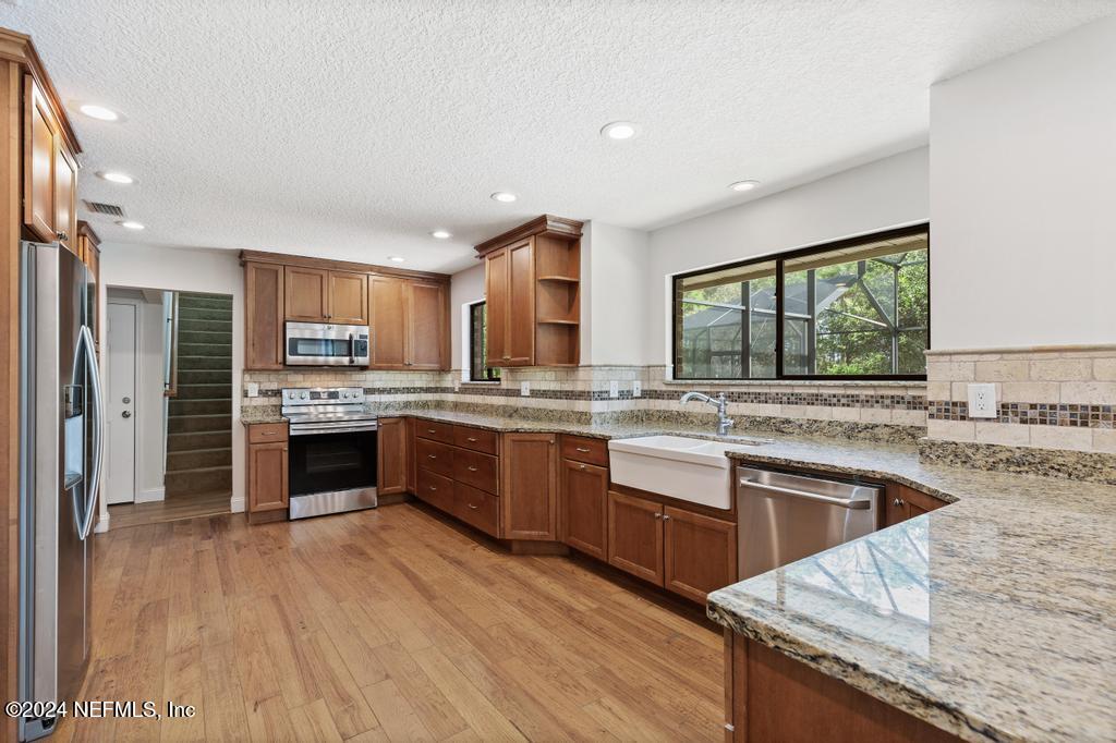 2552 St Augustine Boulevard St. Augustine, FL 32086 - Photo 9 of 50 a kitchen with stainless steel appliances granite countertop a stove a sink dishwasher a refrigerator and a oven with wooden floor