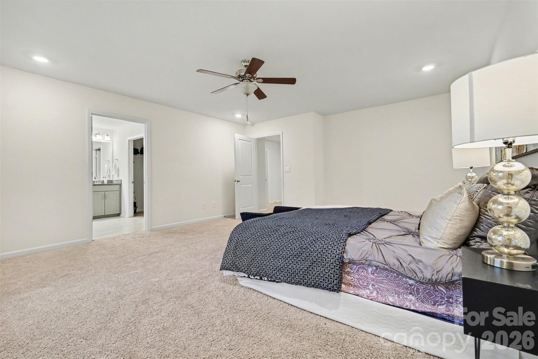 4293 Plumeria Way Fort Mill, SC 29707 - Photo 18 of 33 a spacious bedroom with a bed and ceiling fan