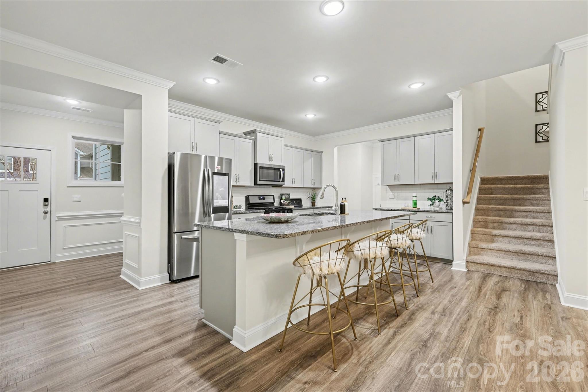 4293 Plumeria Way Fort Mill, SC 29707 - Photo 5 of 33 a kitchen with white cabinets and stainless steel appliances