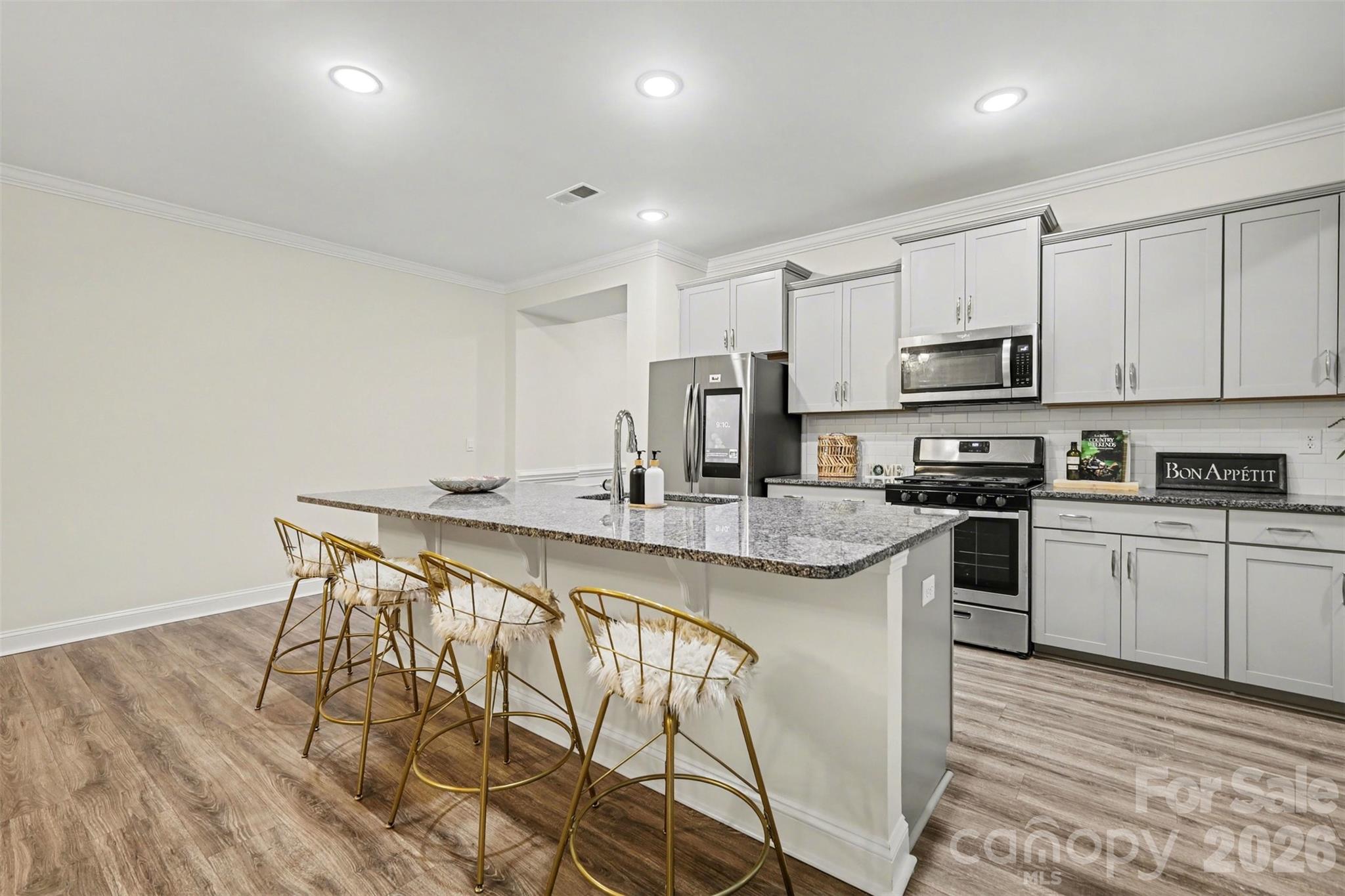 4293 Plumeria Way Fort Mill, SC 29707 - Photo 6 of 33 a kitchen with stainless steel appliances granite countertop a white cabinets and wooden floor