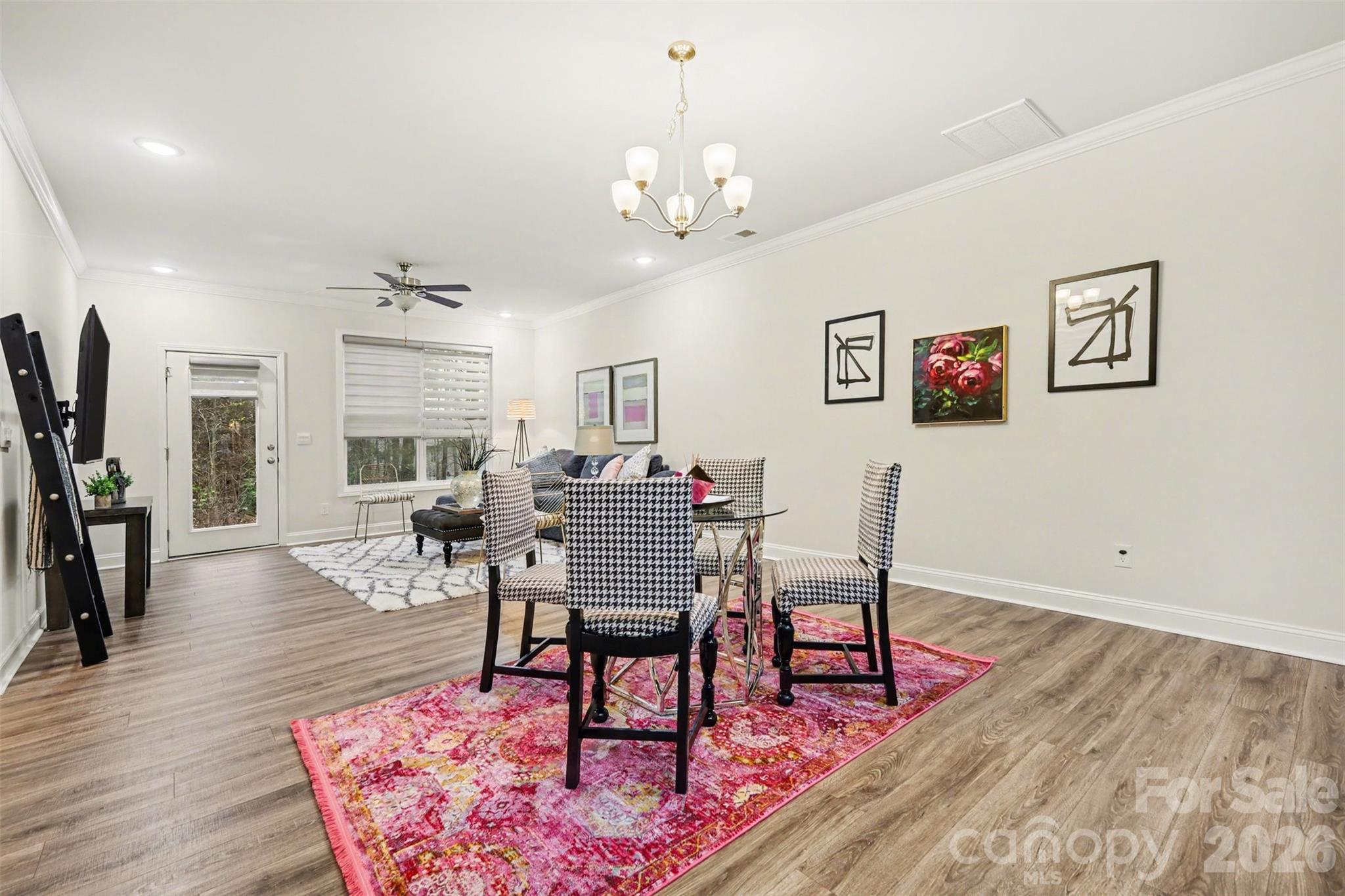 4293 Plumeria Way Fort Mill, SC 29707 - Photo 8 of 33 a dining room with wooden floor a chandelier a wooden table and chairs