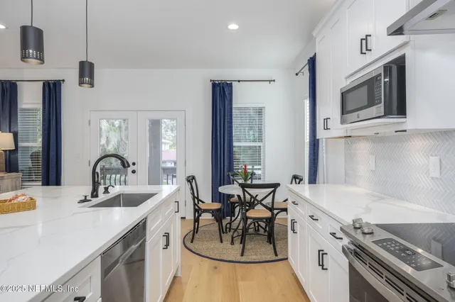 a kitchen with stainless steel appliances granite countertop a sink and a stove top oven