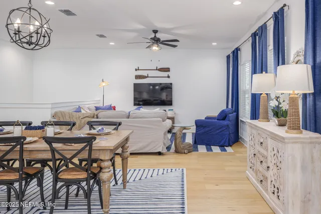 a living room with furniture a chandelier and a flat screen tv