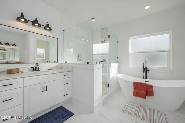 a spacious bathroom with a double vanity sink mirror and bathtub