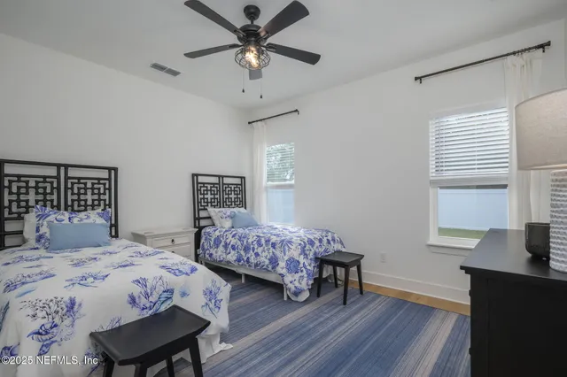 a bedroom with a bed and a table in it with wooden floor