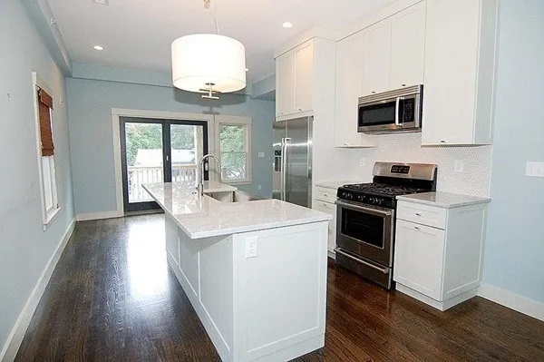 a kitchen with a stove and a wooden floor