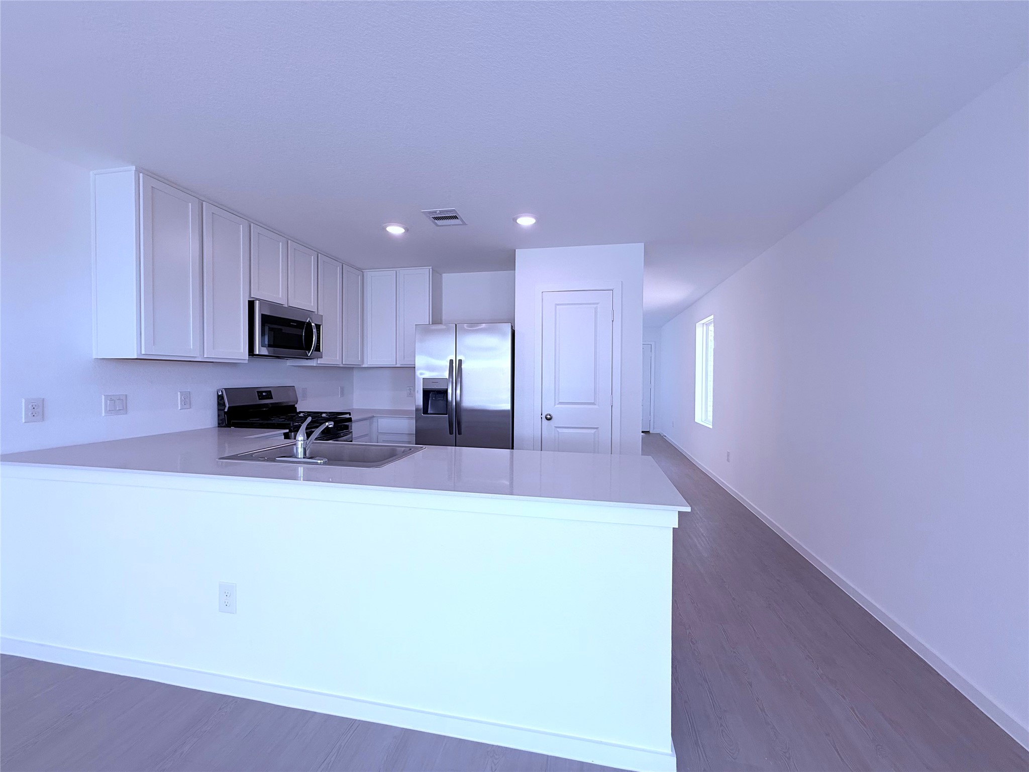 26707 Feather Reed Drive Katy, TX 77493 - Photo 10 of 18 a large white kitchen with kitchen island a sink a stove a refrigerator cabinets and a couch