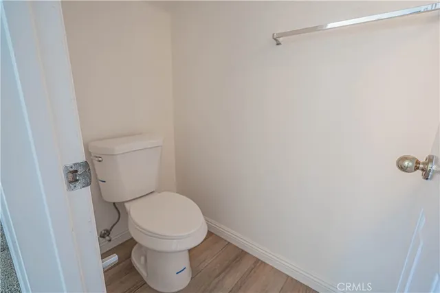 a white toilet sitting in a bathroom next to a wooden wall