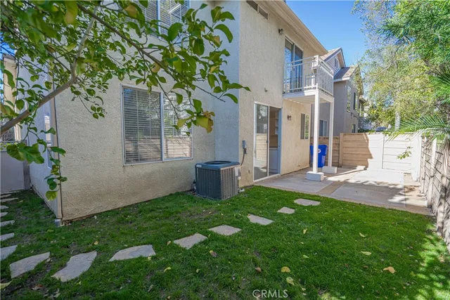 a view of an house with backyard and a tree