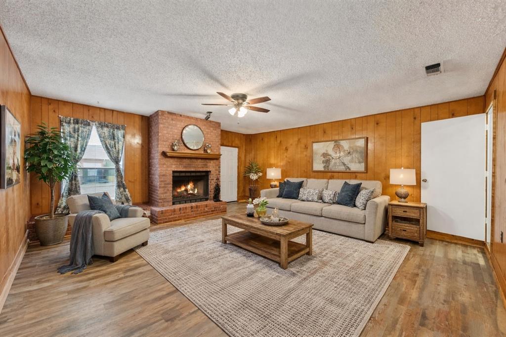 2305 Gilbert Circle Arlington, TX 76010 - Photo 2 of 38 a living room with furniture a fireplace and a large window