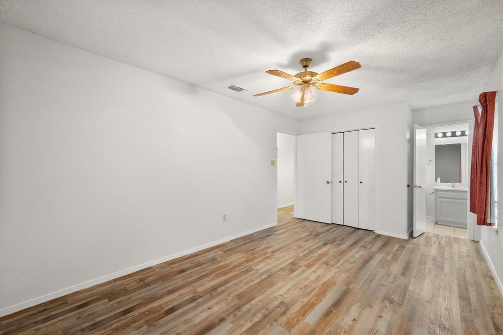 2305 Gilbert Circle Arlington, TX 76010 - Photo 21 of 38 a view of a room with wooden floor and a ceiling fan