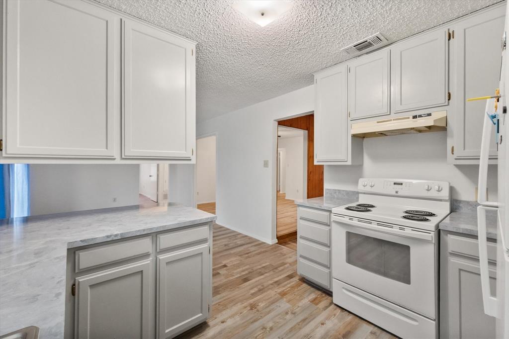 2305 Gilbert Circle Arlington, TX 76010 - Photo 29 of 38 a kitchen with white cabinets and white appliances
