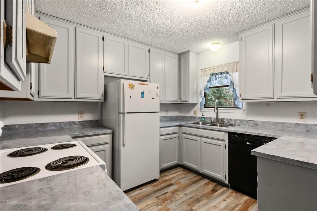 2305 Gilbert Circle Arlington, TX 76010 - Photo 6 of 38 a kitchen with a sink a refrigerator and cabinets