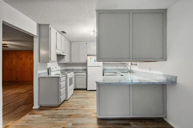a kitchen with a sink stove and cabinets