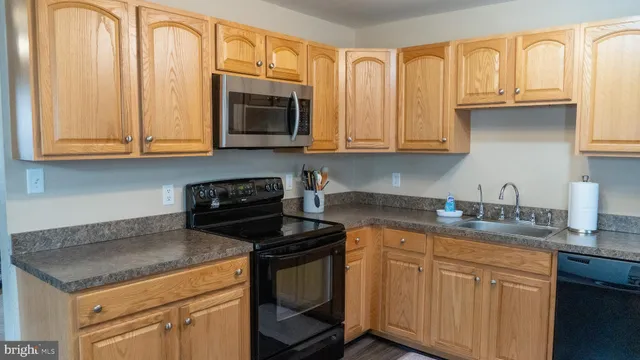 a kitchen with granite countertop a sink and a stove
