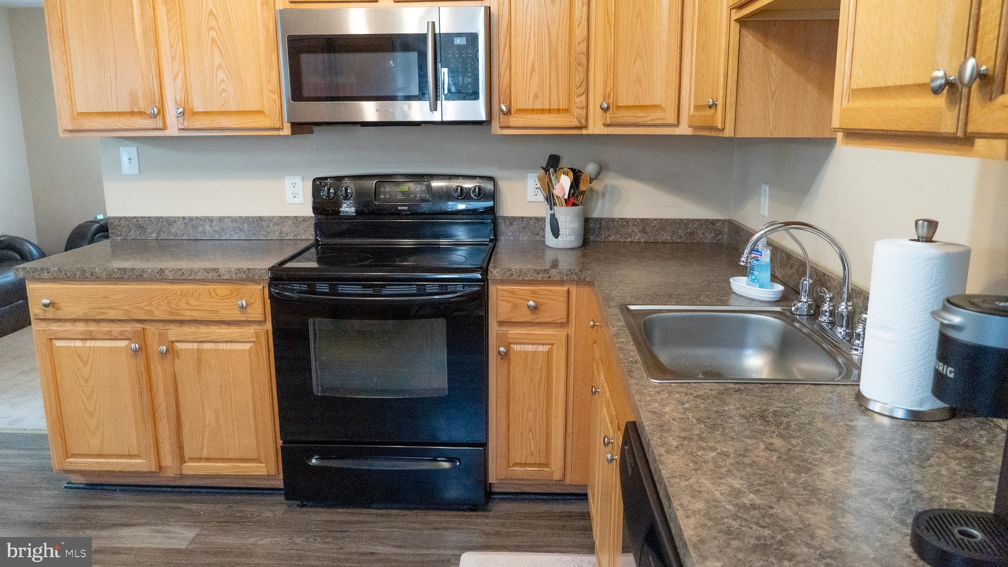 3705 Firetower Road Felton, DE 19943 - Photo 24 of 40 a kitchen with granite countertop a stove top oven microwave and cabinets