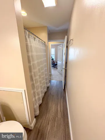 a walk in closet with wooden floor