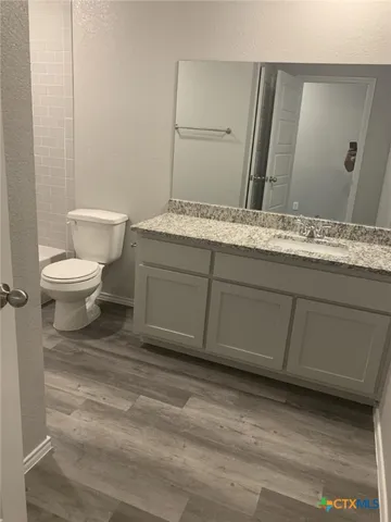 a bathroom with a granite countertop sink and vanity