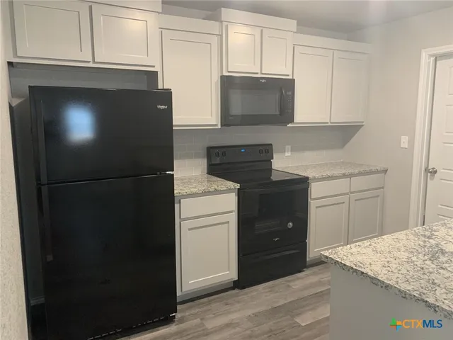 a kitchen with a refrigerator and cabinets